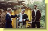 Don Pedro greets Leonato, while Balthasar looks on